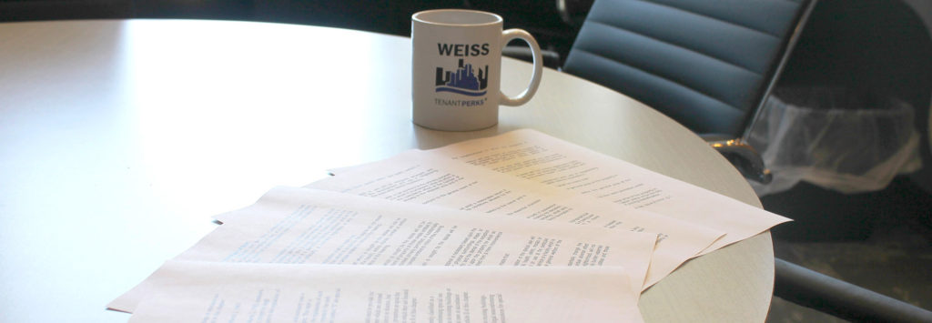 Design/Build forms on a table with Weiss Properties Mug in background